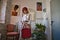 Young, beautiful, bohemian Latina, wearing a red beret on her head and a red vintage suitcase, looking happily at the camera for