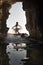 Young beautiful bride dancing under rock archway outdoors