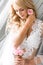 Young beautiful bride fixing a small pink rose bud