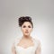 Young and beautiful bride over the grey background