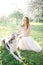 Young beautiful bride in wedding dress with greyhound outdoors
