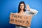 Young beautiful brunette activist woman holding banner protesting to care the planet with open hand doing stop sign with serious