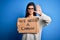 Young beautiful brunette activist woman holding banner protesting to change with open hand doing stop sign with serious and