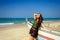 Young beautiful brunette in beach dress on blue sea near wooden fishing boat. Summer tropical relaxation outdoor, carefree