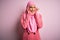 Young beautiful brunette businesswoman wearing pink muslim hijab and business jacket covering ears with fingers with annoyed