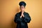 Young beautiful brunette chef woman wearing cooker uniform and hat over yellow background begging and praying with hands together