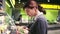 Young beautiful brunette girl in her 20`s trying to choose prepacked salad leaves in a grocery store.