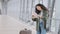 Young beautiful brunette hispanic woman standing with suitcase at airport holding map looking for route road direction