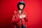 Young beautiful brunette motocyclist woman wearing motorcycle helmet and red jacket smiling with hands on chest with closed eyes