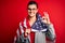 Young beautiful brunette patriotic woman wearing usa flag celebrating independence day doing ok sign with fingers, excellent