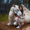 young beautiful brunette in a rider costume is sitting next to large white camel