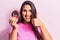 Young beautiful brunette woman holding chocolate donut smiling happy and positive, thumb up doing excellent and approval sign