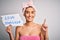 Young beautiful brunette woman holding paper with love yourself message after shower surprised with an idea or question pointing