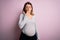 Young beautiful brunette woman pregnant expecting baby over isolated pink background bored yawning tired covering mouth with hand