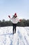 Young beautiful brunette woman slides from a snow slide against the background of the forest and blue sky. Winter sunny day