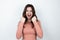 Young beautiful brunette woman standing on isolated white background holding two fists in boxing position, splash of emotions