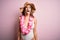 Young beautiful brunette woman on vacation wearing swimsuit and Hawaiian flowers lei sticking tongue out happy with funny