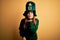 Young beautiful brunette woman wearing green hat on st patricks day celebration looking at the camera blowing a kiss with hand on