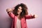 Young beautiful businesswoman with curly hair and piercing wearing elegant jacket approving doing positive gesture with hand,