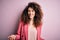 Young beautiful businesswoman with curly hair and piercing wearing elegant jacket smiling cheerful with open arms as friendly