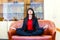 Young beautiful businesswoman meditates on sofa in office