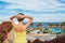 Young beautiful caucasian female in vibrant yellow dress looks at the sea