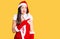 Young beautiful caucasian woman wearing santa claus costume pointing aside worried and nervous with forefinger, concerned and