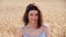 Young beautiful caucasian woman in wheat field, close-up portrait. Positive girl smiling, enjoying summer