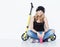 Young beautiful cheerful fashion girl in jeans, sneakers, hat sits on a yellow scooter and listening to music on headphones. Keeps