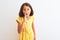 Young beautiful child girl wearing yellow floral dress standing over isolated white background hand on mouth telling secret rumor,