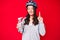 Young beautiful chinese girl wearing bike helmet and holding water bottle smiling with an idea or question pointing finger with