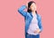 Young beautiful chinese woman pregnant expecting baby confuse and wondering about question