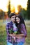 Young beautiful couple embracing and smiling at sunset in summer