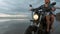 Young beautiful couple hipsters riding retro motorcycle on the beach, outdoor portrait, riding guy and girl, travel