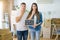 Young beautiful couple holding blackboard with our first home text at new house cover mouth with hand shocked with shame for