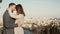 Young beautiful couple hug and kiss against the panorama of Rome, Italy. Romantic date of happy man and woman.