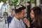 Young beautiful couple in love looking at each other in the eye near the post with flowers while walking in Lviv when filming love