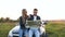 Young beautiful couple sitting on the cabriolet and using map.