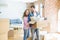 Young beautiful couple very happy together holding cardboard boxes moving to a new home