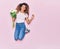 Young beautiful curly woman with tattoo holding bouquet of white rose smiling happy