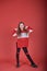 Young beautiful cute girl dancing on red background, modern slim hip-hop style teenage girl jumping