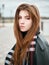 Young beautiful emotional redhead woman in stylish trench coat, big plaid scarf enjoying vacations free time on a background of