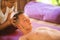 Young beautiful and exotic Asian Thai therapist woman giving traditional head and facial Balinese massage to Caucasian man at