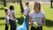 Young beautiful family recycle plastic bottle woman posing for camera during cleaning green park on summer day spbi.