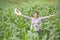 A young and beautiful farmer happily smiles in his corn garden.