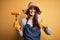 Young beautiful farmer woman wearing apron and hat holding fork with cob corn happy with big smile doing ok sign, thumb up with