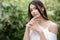 Young beautiful fashionable girl in stylish jewelry. The model poses in the street with flowering trees. Spring fashion concept