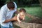 Young beautiful father and little toddler son against green grass