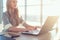 Young beautiful female copywriter typing texts and blogs in spacious light office, her workplace, using pc keyboard