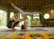 Young beautiful and fit woman with acrobat man as yoga coach learning balance posture in acroyoga workout at exotic fitness studio